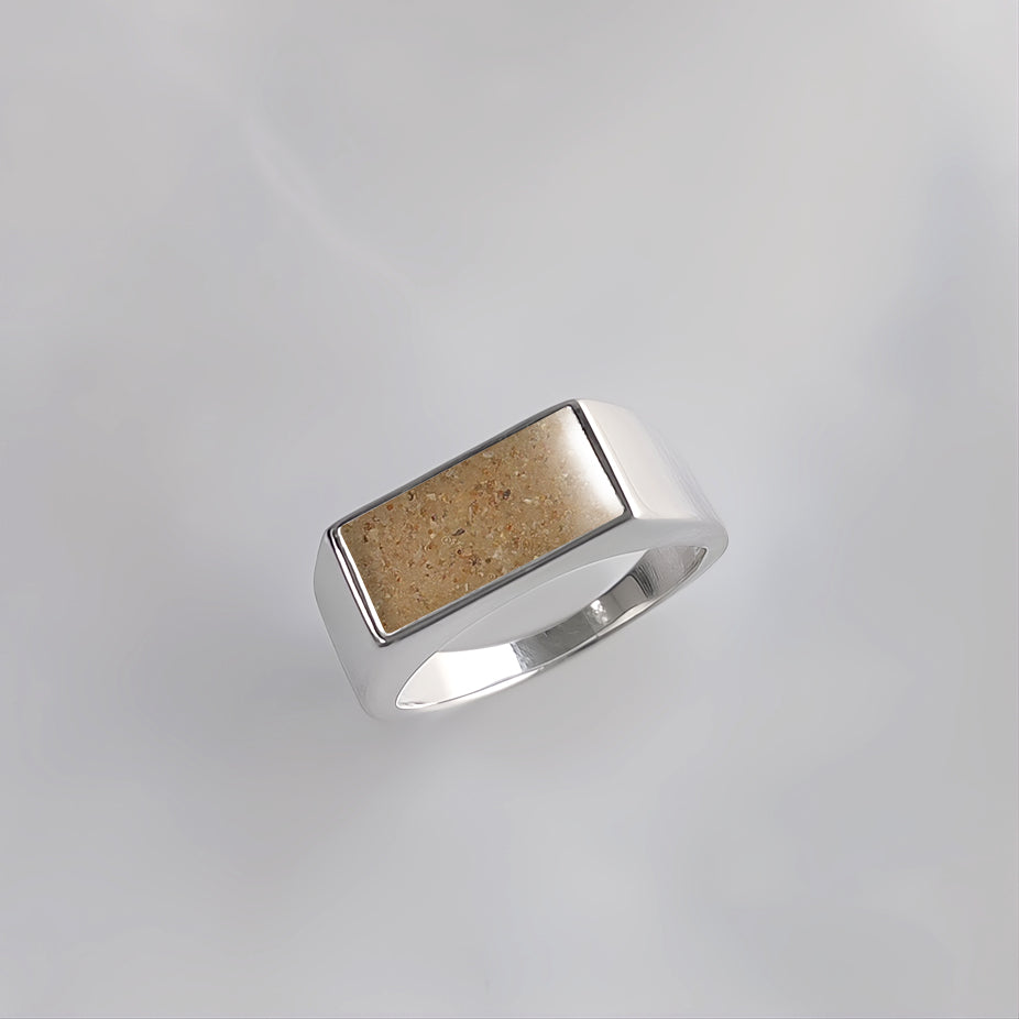 Anillo de plata con gema de arena o tierra en forma de sello de hombre.