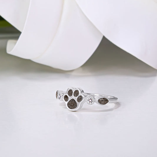 Anillo de plata con huella de perro rellena de cenizas de mascota y circonitas a los lados