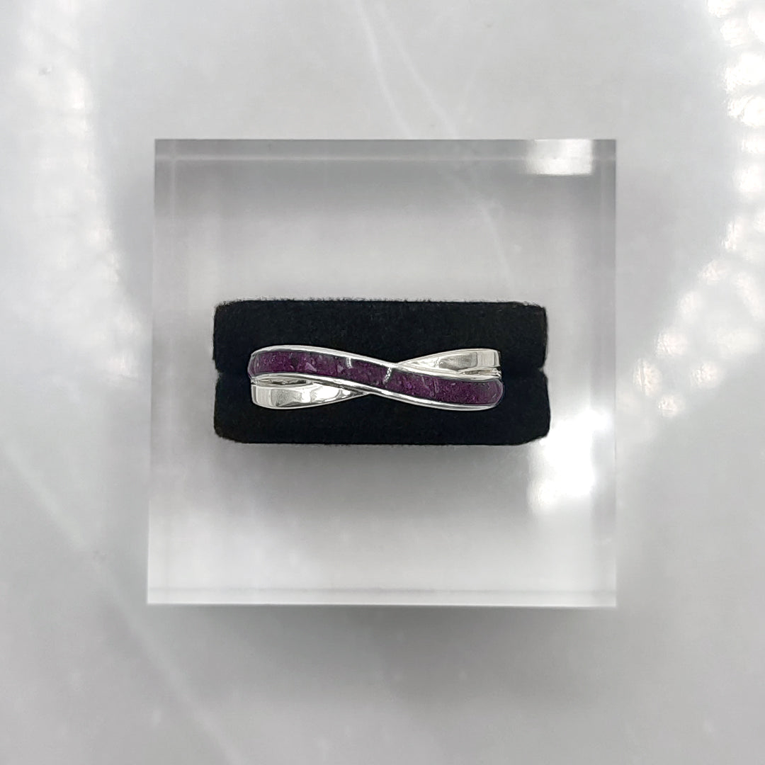 Anillo de plata con cenizas en banda cruzada con un tono púrpura.