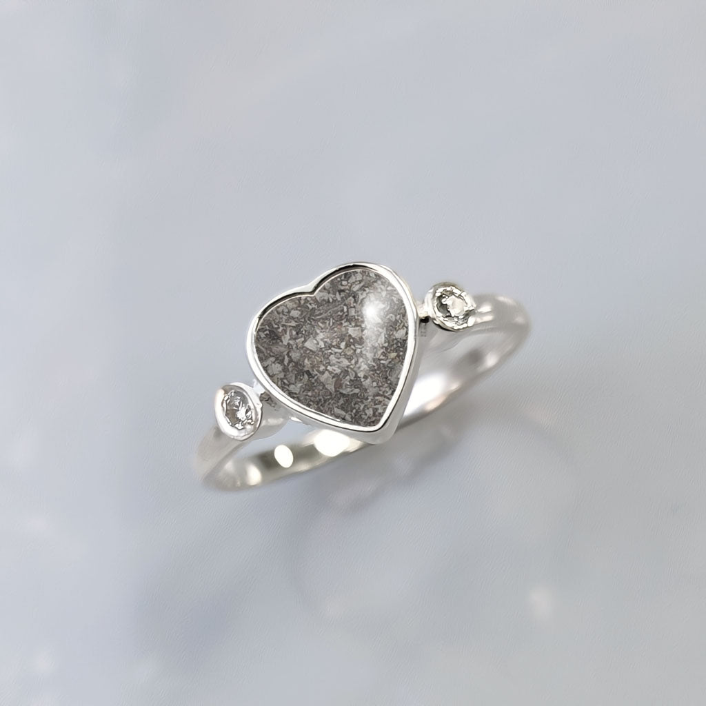 Anillo de plata con cenizas dentro de corazón y con dos circonitas, una a cada lado.