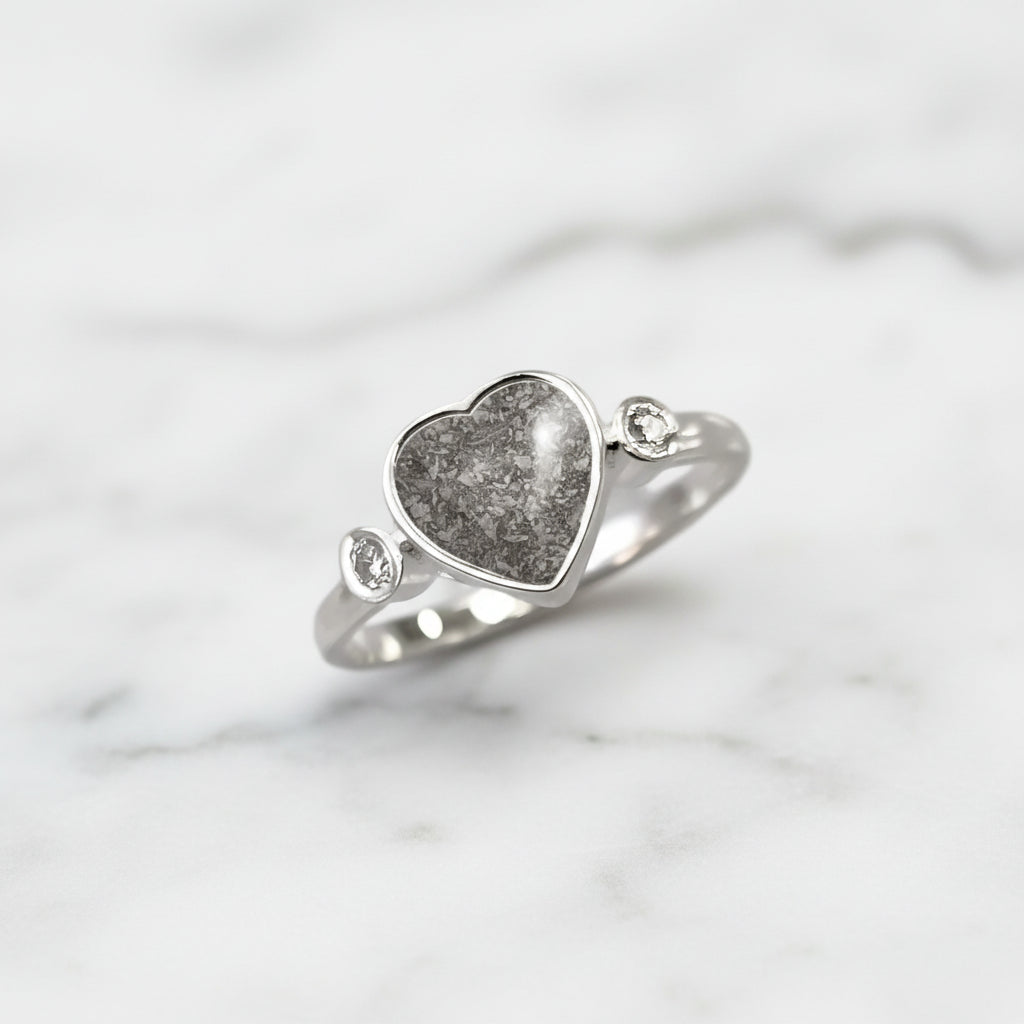 Anillo de plata con cenizas dentro de corazón y con dos circonitas, una a cada lado.