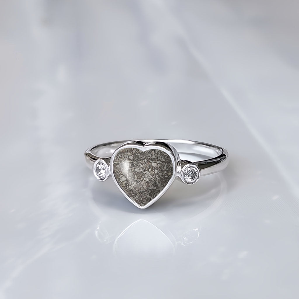 Anillo de plata con cenizas dentro de corazón y con dos circonitas, una a cada lado.