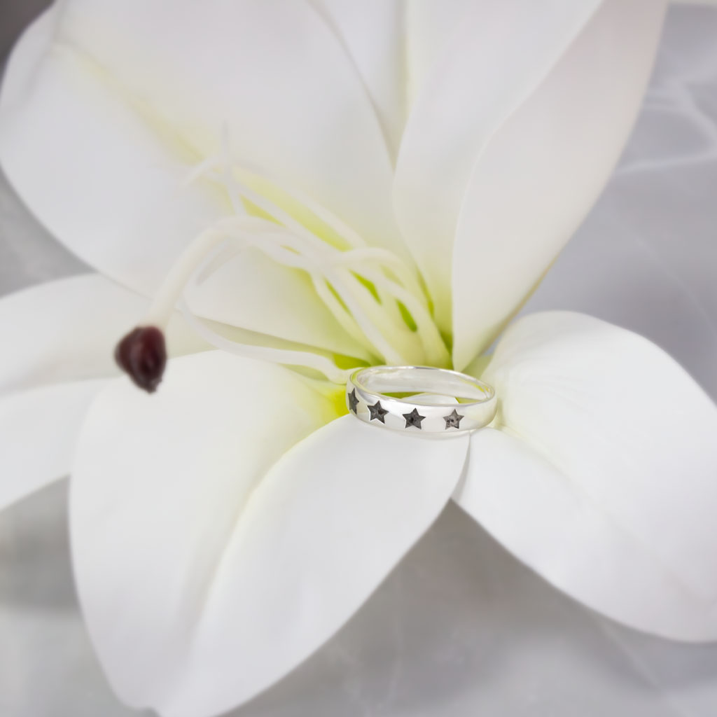 Anillo de plata con estrellas talladas que contienen la ceniza de un ser querido.