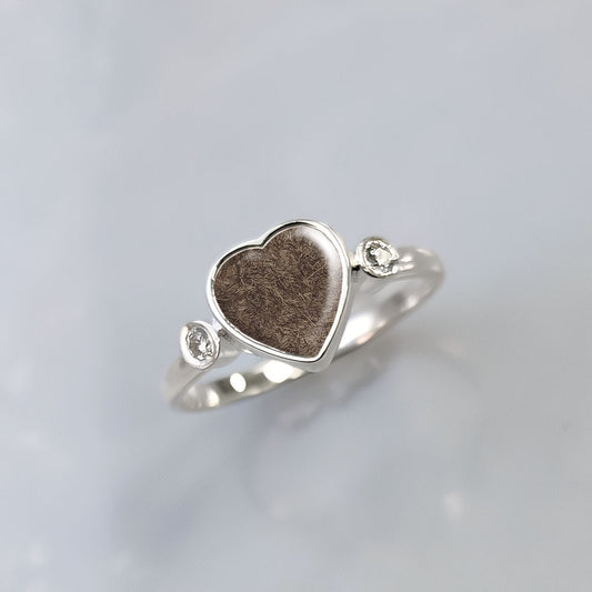 Anillo con pelo de perro, gato o mascota dentro de corazón de plata con dos circonitas.