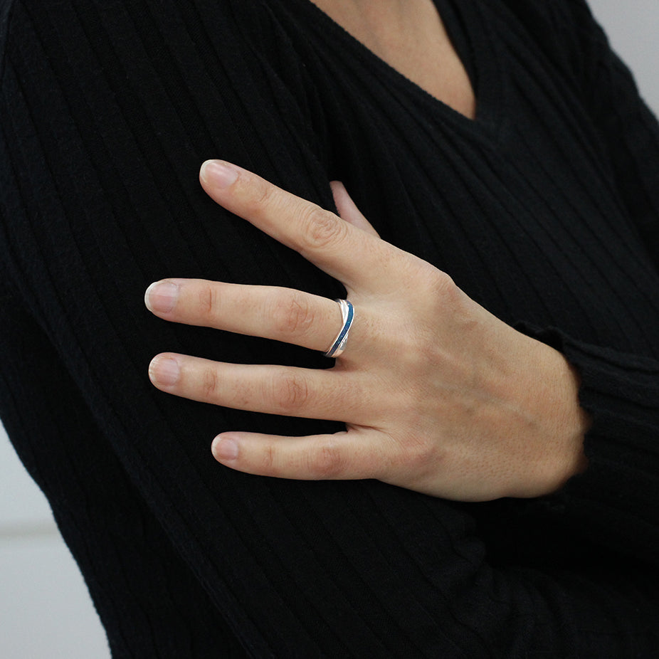 Anillo de plata en mano con cenizas y pigmentación azul