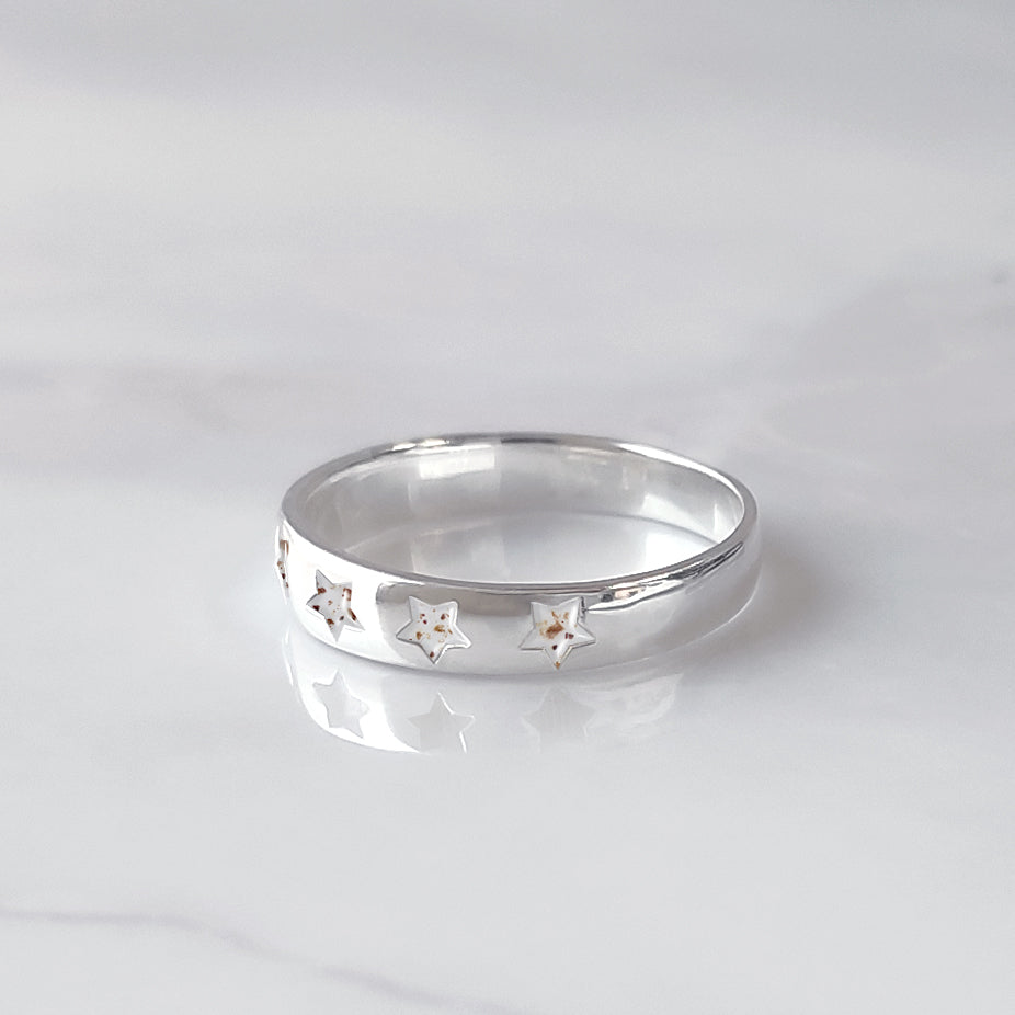 Anillo de plata con cordón umbilical en estrellas talladas.