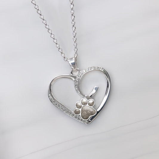 Colgante con cenizas de tu mascota dentro de una huella custodiada por un corazón de plata rodeado de circonitas.