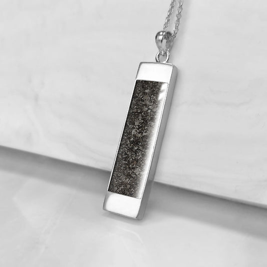 Colgante rectangular en plata con cenizas de mascota en su interior.