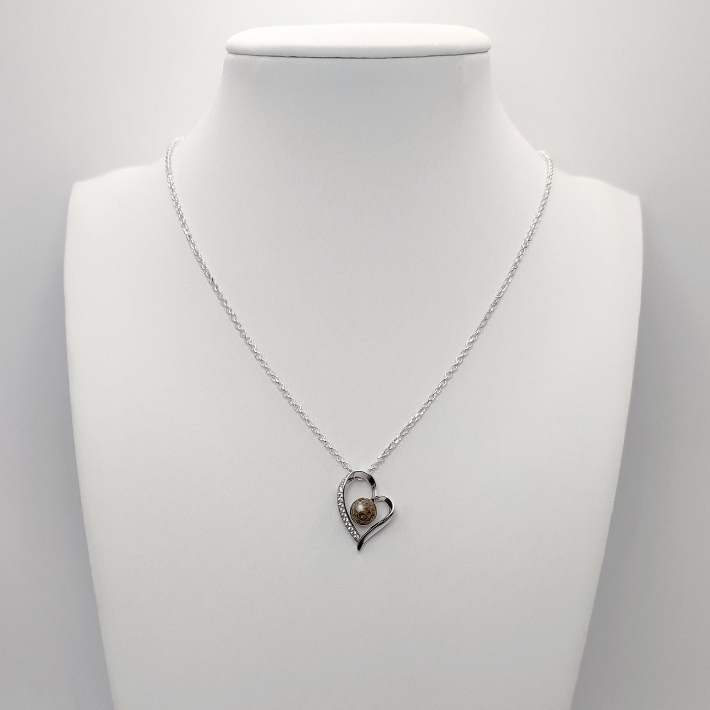Colgante con cenizas dentro de un corazón de plata con circonitas