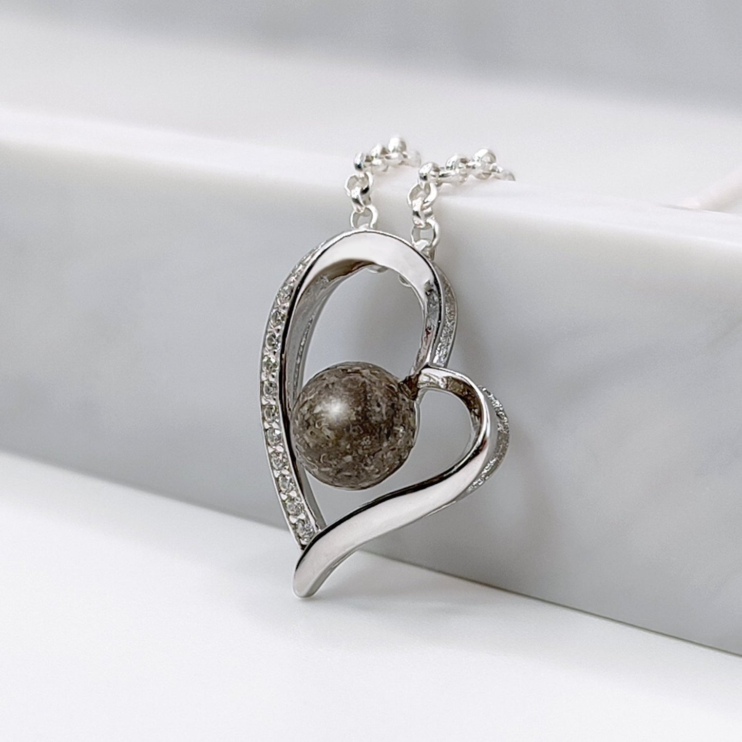 Colgante con cenizas dentro de un corazón de plata con circonitas