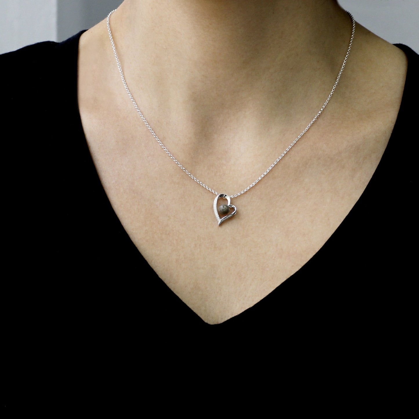 Colgante con cenizas dentro de un corazón de plata con circonitas