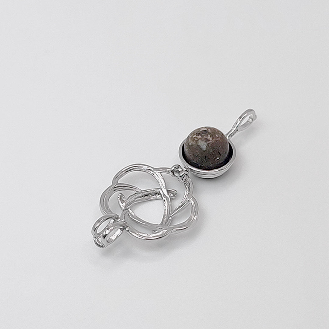 Colgante de plata con cenizas dentro de plata en forma de flor. Esfera.