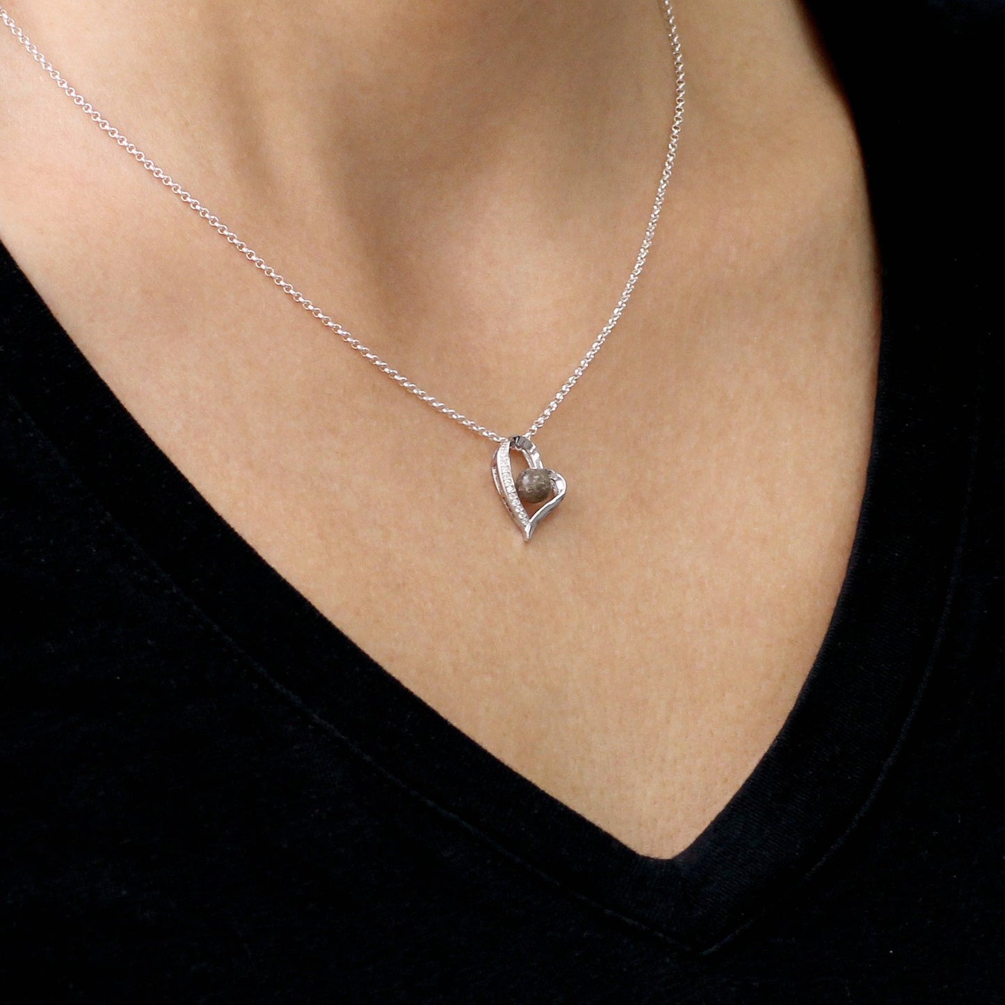 Colgante de plata con cenizas en gema central dentro de corazón con circonitas
