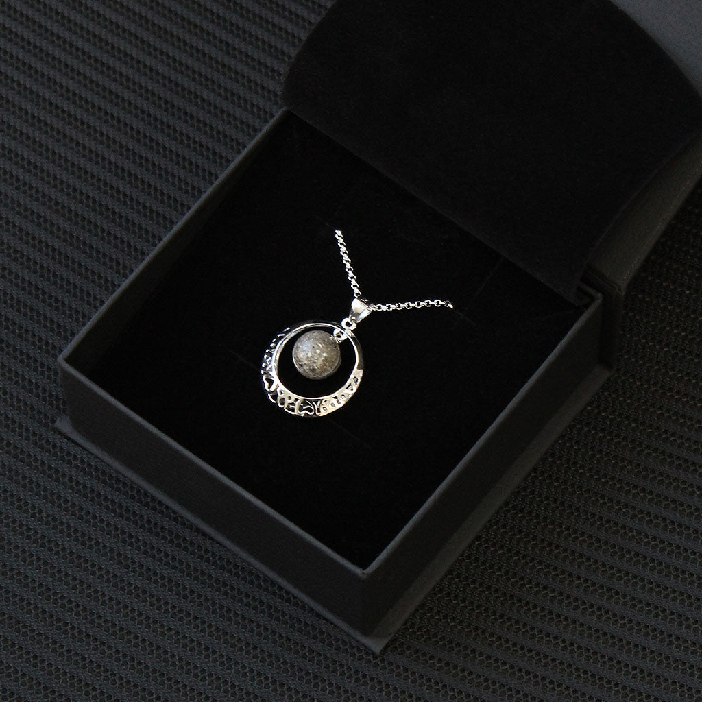 Colgante con cenizas en esfera dentro de aro de plata con corazones