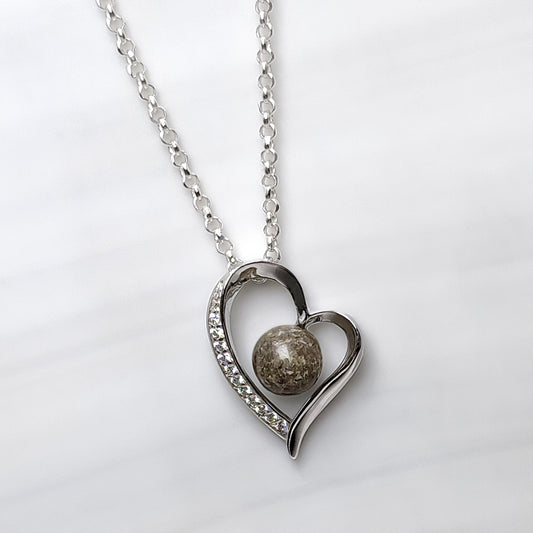 Colgante con cenizas dentro de un corazón de plata con circonitas