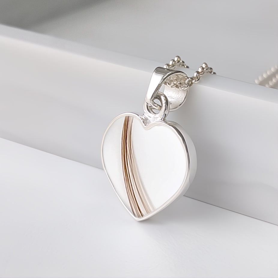 Colgante con pelo · Corazón de plata con pelo