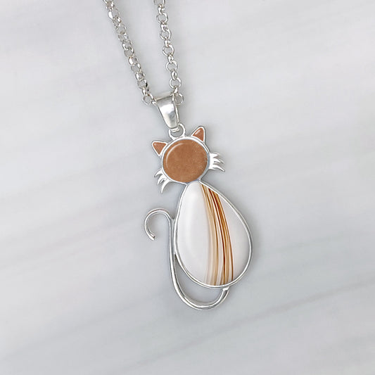 Colgante de plata en forma de gato que contiene pelo de mascota en orejas, cabeza y cuerpo.