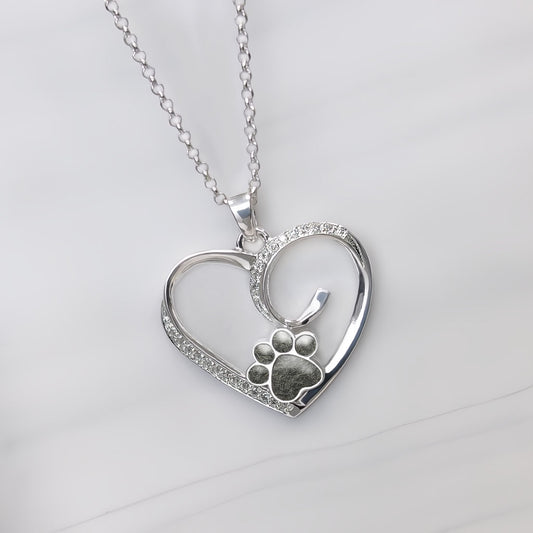 Colgante con pelo de tu mascota dentro de huella custodiada por un corazón de plata con circonitas.