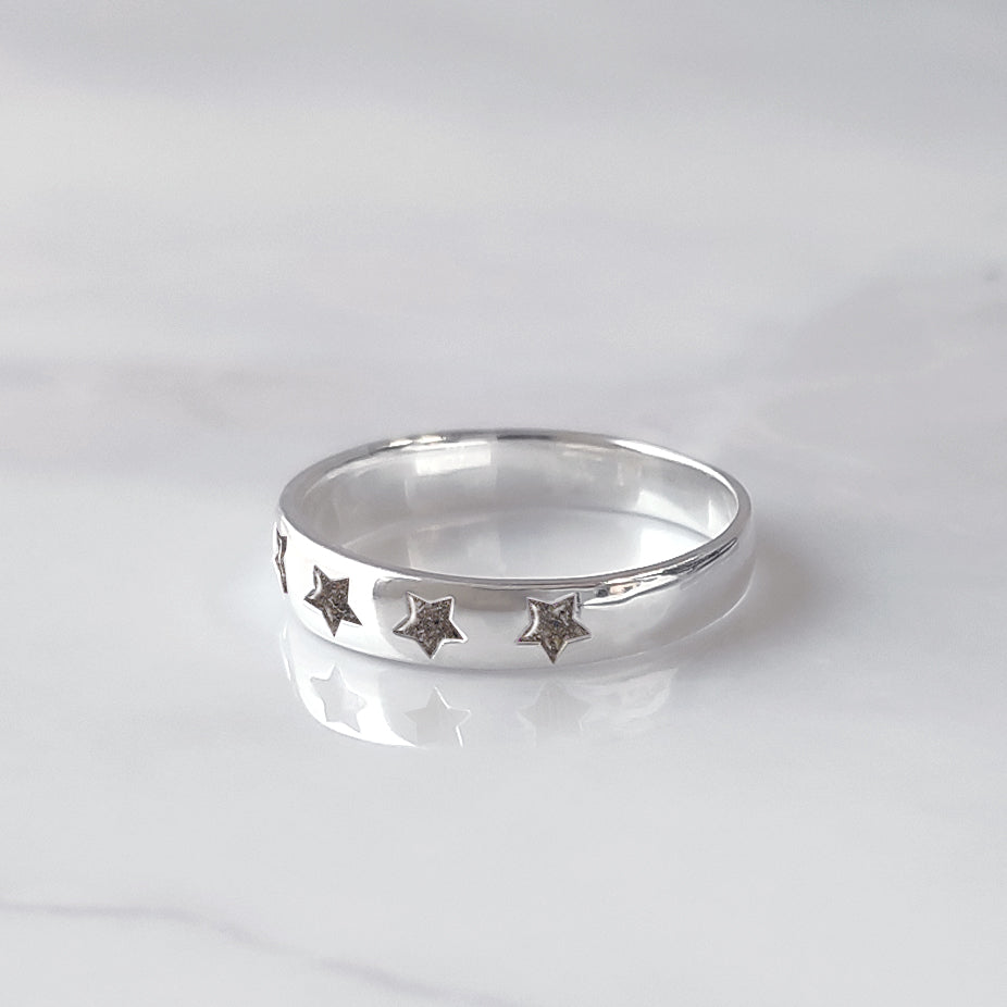 Anillo de plata con estrellas talladas que contienen la ceniza de un fiel compañero peludo.