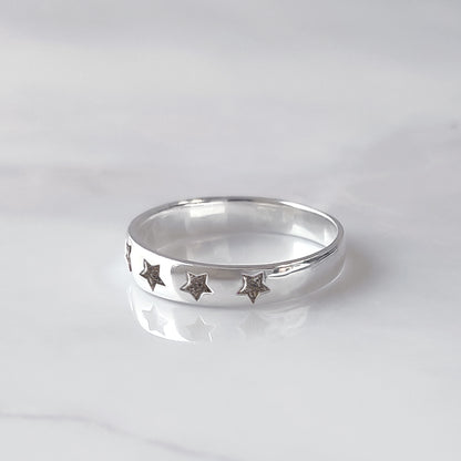 Anillo de plata con estrellas talladas que contienen la ceniza de un fiel compañero peludo.