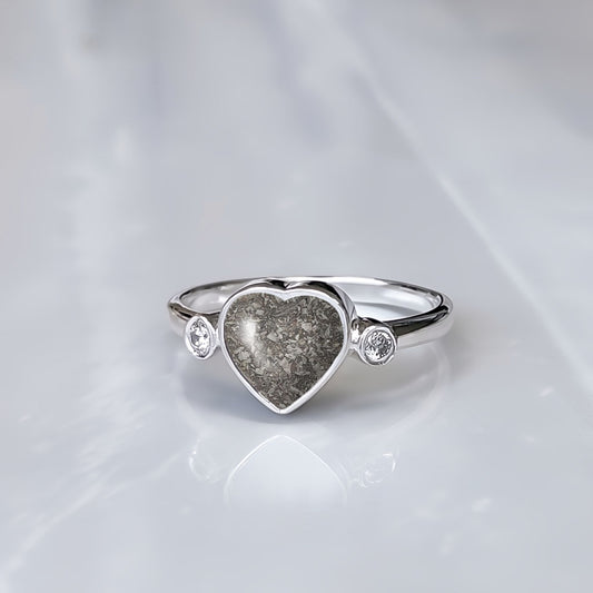 Anillo de plata con cenizas dentro de corazón y con dos circonitas, una a cada lado.
