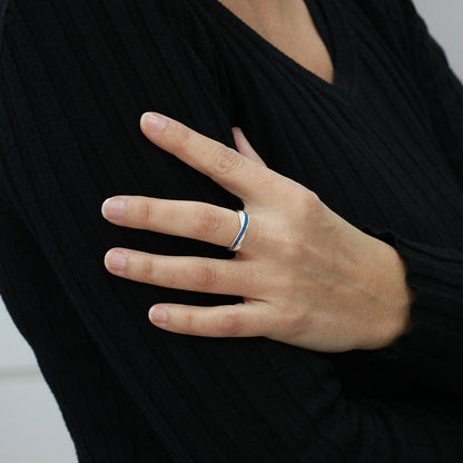 Anillo de plata en mano con cenizas y pigmentación azul