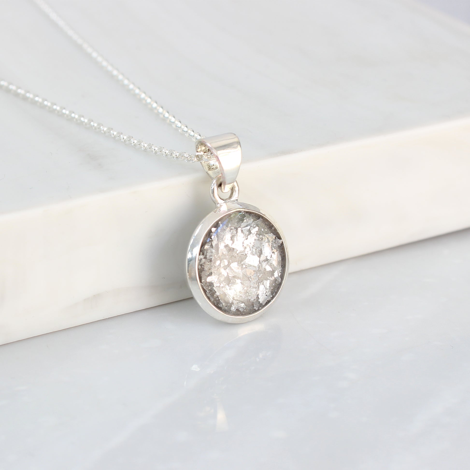 Colgante con Cenizas en Fondo Brillante Plateado dentro de un Círculo