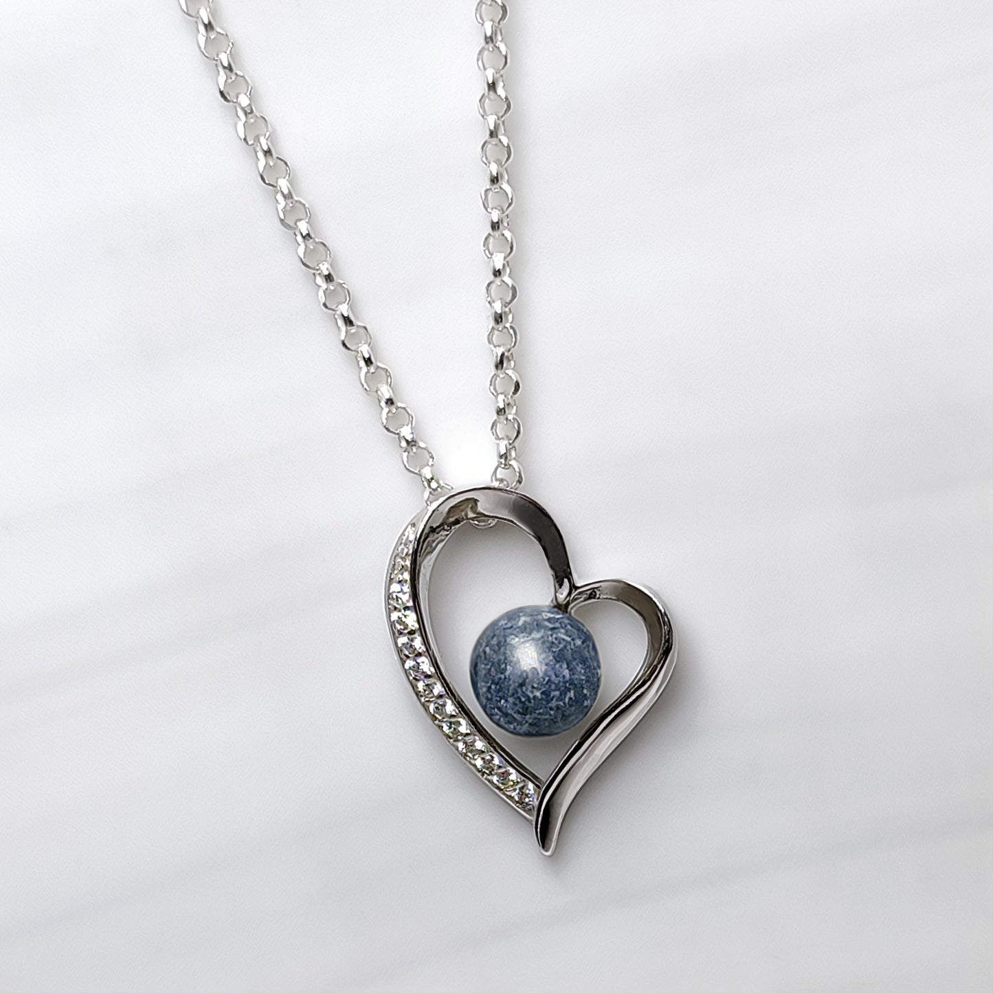 Colgante con cenizas de mascota en corazón con cenizas. Celeste