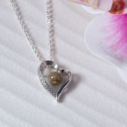 Colgante con cenizas dentro de un corazón de plata con circonitas