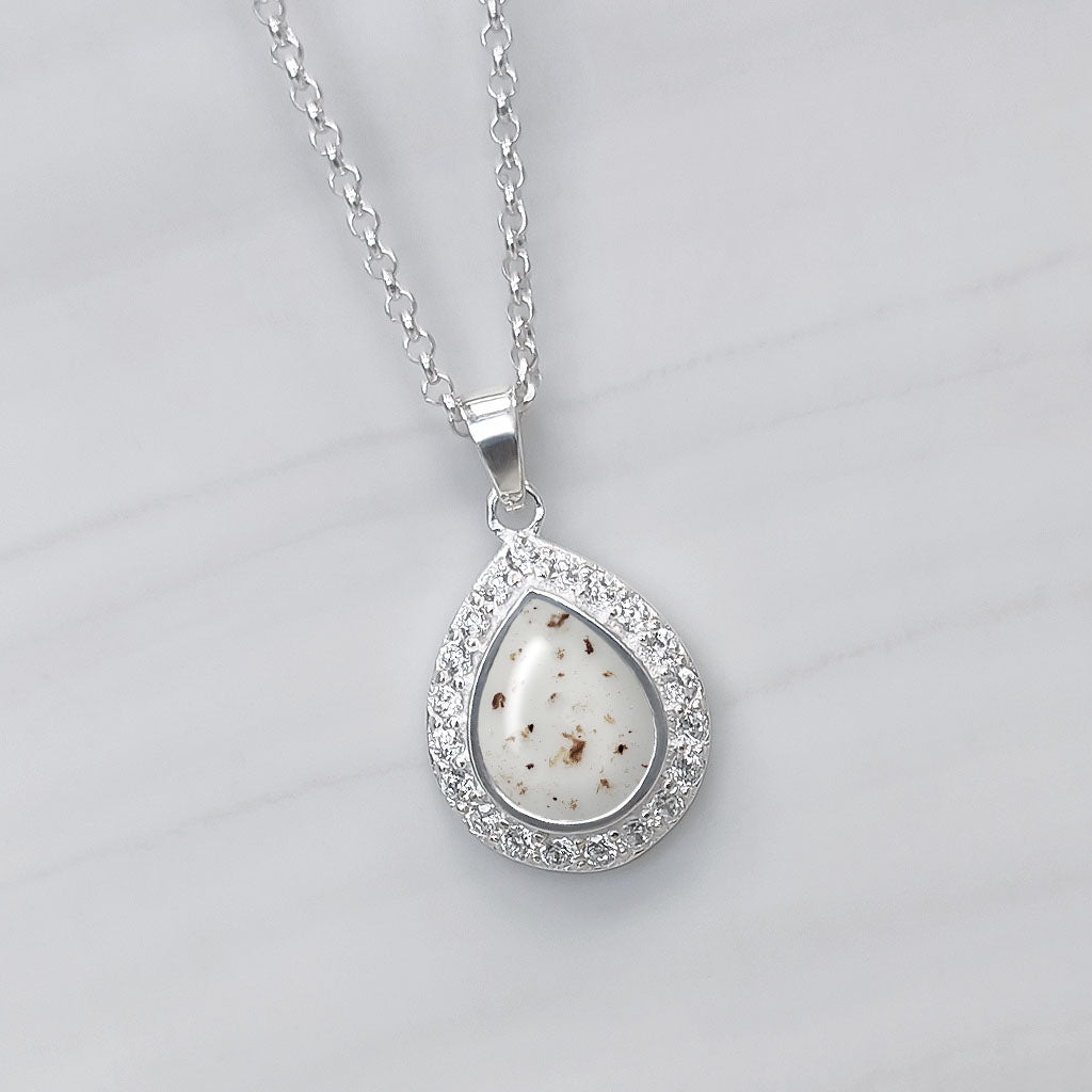 Colgante con cordón umbilical en lágrima de plata rodeada de circonitas.