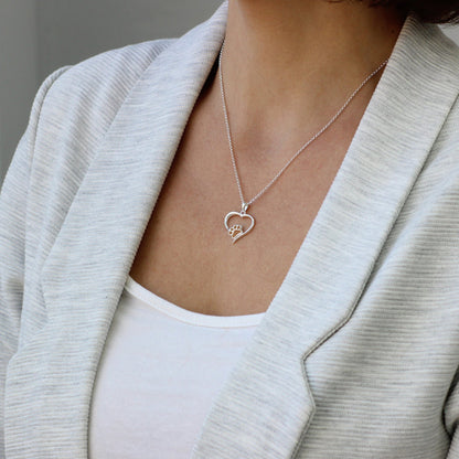 Colgante de plata con pelo de perro o gato dentro de corazón. 