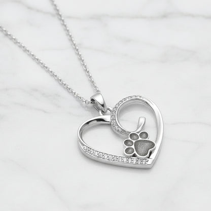 Colgante con pelo de tu mascota dentro de huella custodiada por un corazón de plata con circonitas.