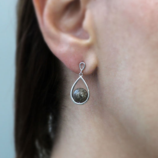 Pendientes con esfera de cenizas dentro de bisel de lágrima de plata.